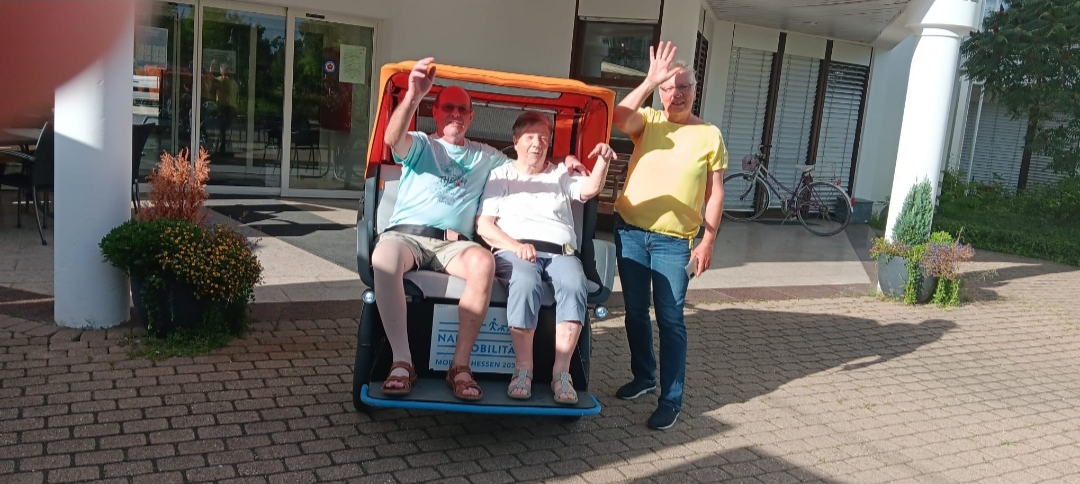 Zwei Fahrgäste und ein Fahrer vor der Rikscha